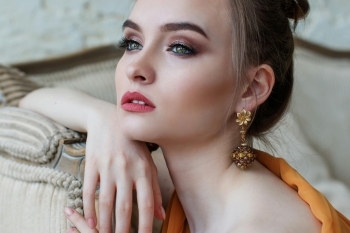 gorgeous model with pink lips, an ornate earring and flawless skin.