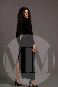 London escort Amal stood wearing a long flowing black dress