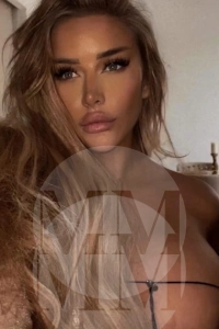 Carmen taking a selfie in the nude, her nipples just out of frame.