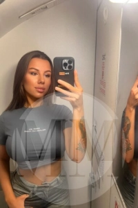 Crystal taking a selfie wearing a grey crop top and jeans
