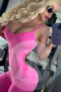 London escort Krissy taking a selfie in a pink bodysuit