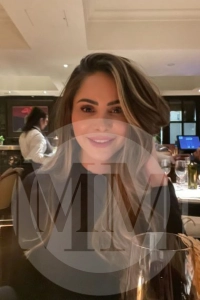 London escort Monica at a restaurant in a black dress