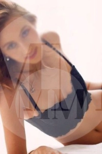 London escort Tia lay on the floor wearing a black top